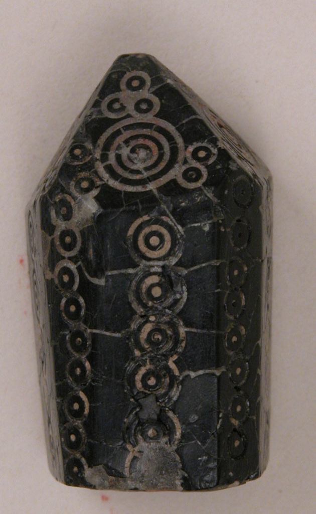 Pawn made of black jet, decorated with a dot and circle motif.