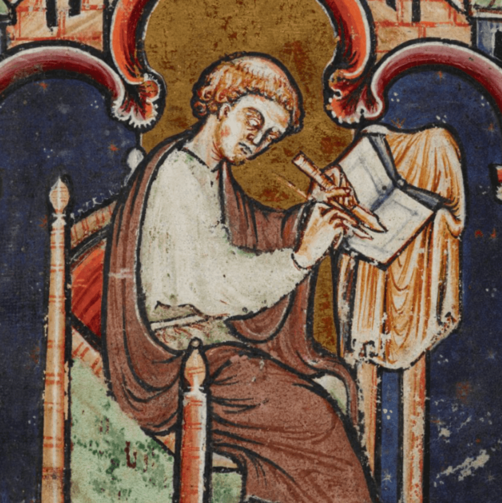 Medieval manuscript image of a tonsured scribe sitting at a desk and writing in an open book; he holds a writing tool in each hand and is concentrating very hard on his task.