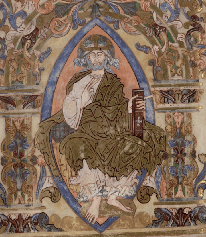 Medieval manuscript image of a grey-bearded man wearing a golden robe and crown with a halo, framed in a blue mandorla, around which is an arch of intricate foliate decorations.