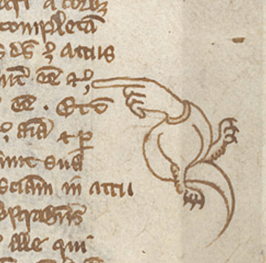 Medieval manuscript with a hand in the margin pointing a finger at the writing; the hand has a wyvern-like body, with clawed feet and a tail.