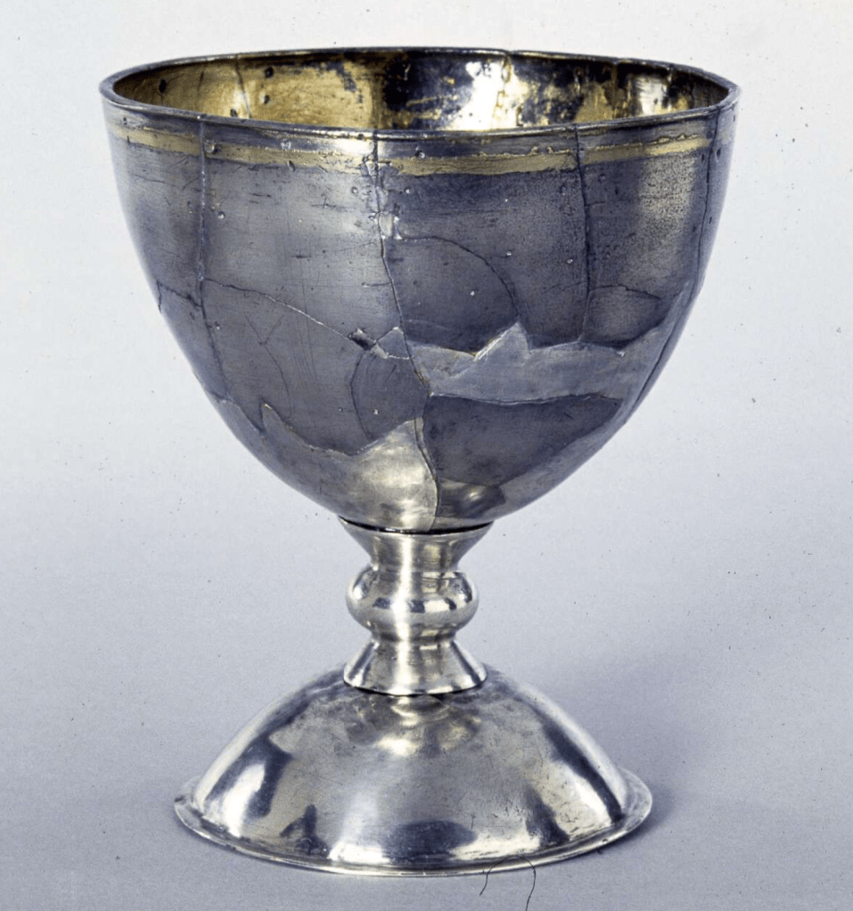 Silver chalice reconstructed from broken pieces, formed of a separate foot, stem and cup; the bowl is gilded on the inside and a band of gilding runs slightly below the rim.
