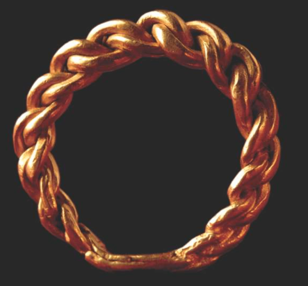 Plaited gold ring, thicker on one side and tapering down to where the ends are joined.