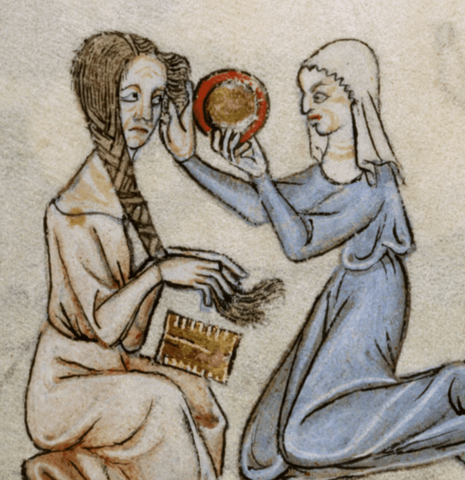 Medieval manuscript illustration of a female servant arranging her mistress’s hair who has a comb in her lap and holds a long plait; the servant holds a mirror in one hand as she works.