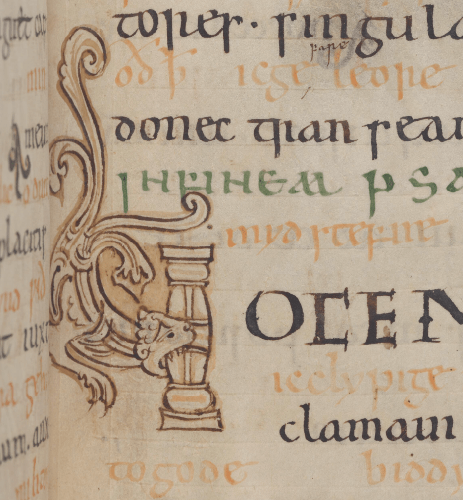 A toothy creature bites into a column forming the letter V in a medieval manuscript.